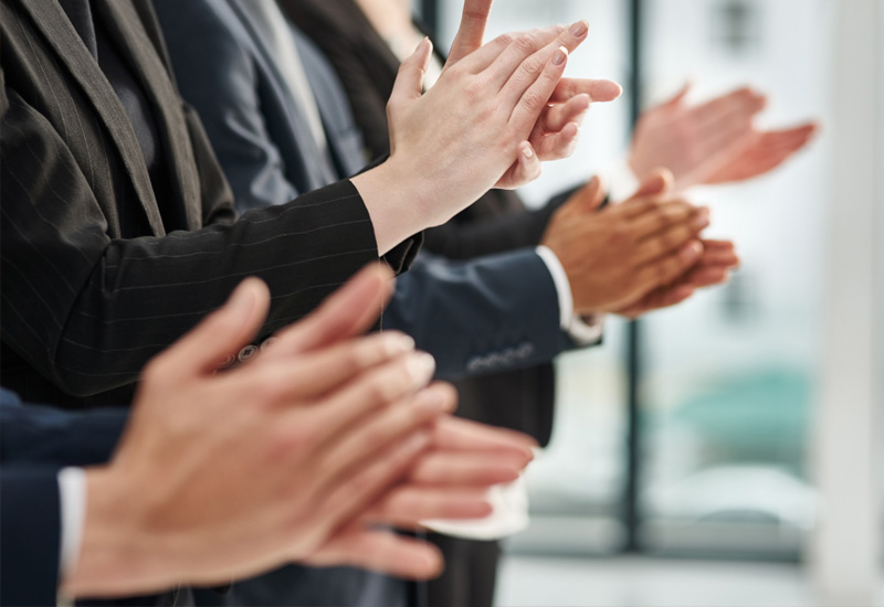 イメージ画像：テーブル越しに握手を交わす笑顔の女性